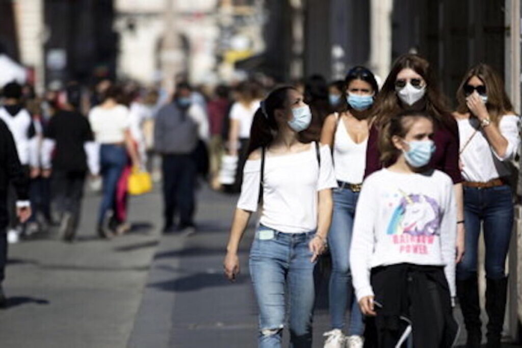 Giovani ragazzi passeggiano con le mascherine