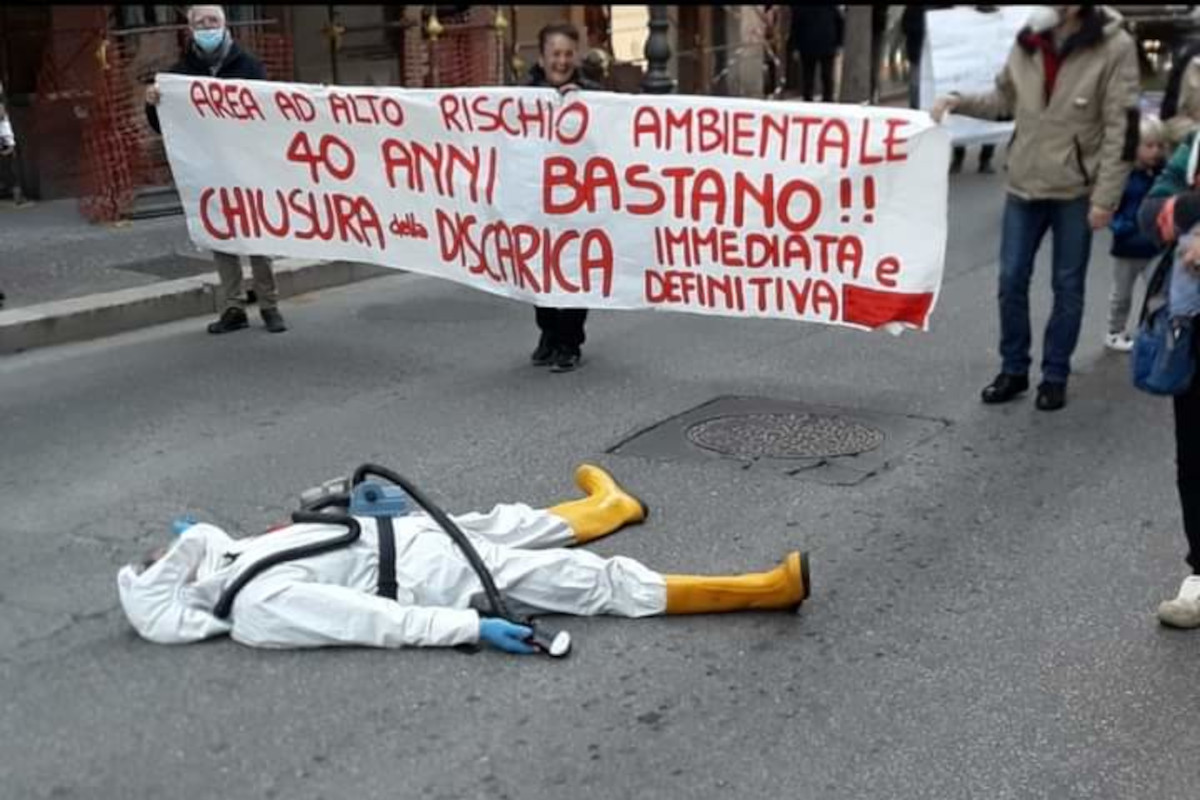 manifestante in tuta anti gas sdraiato a terra, Discarica Albano protesta