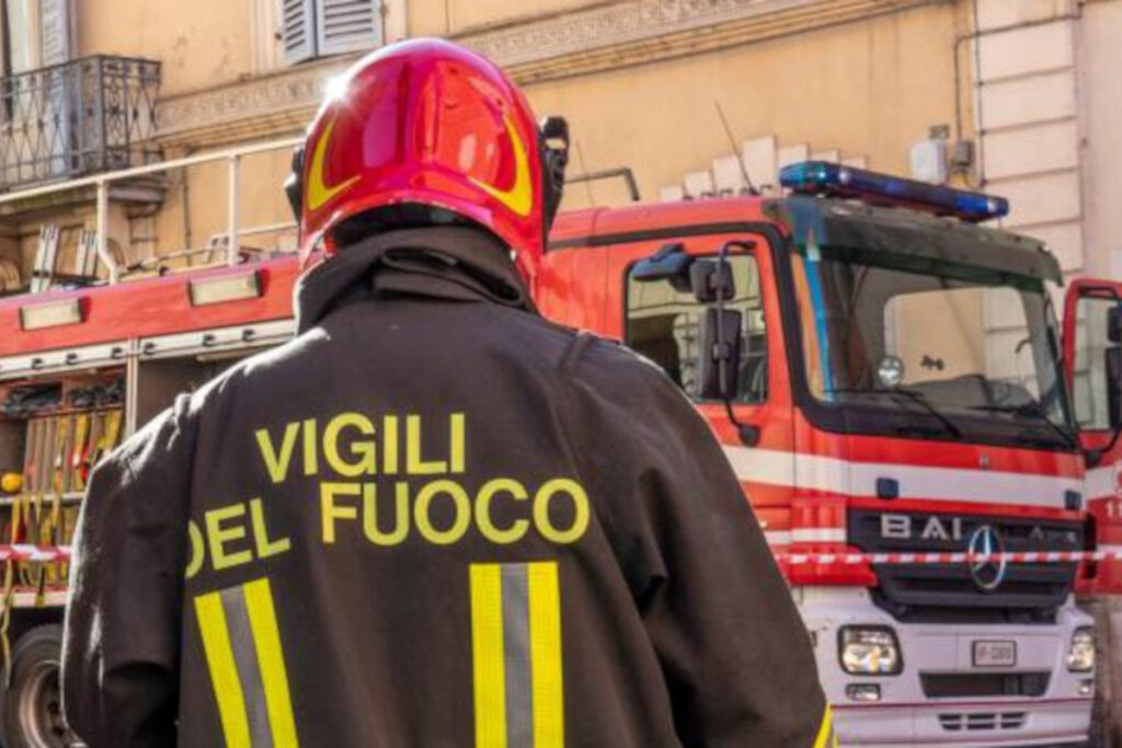 Vigile del fuoco di spalle e mezzo anti-incendio