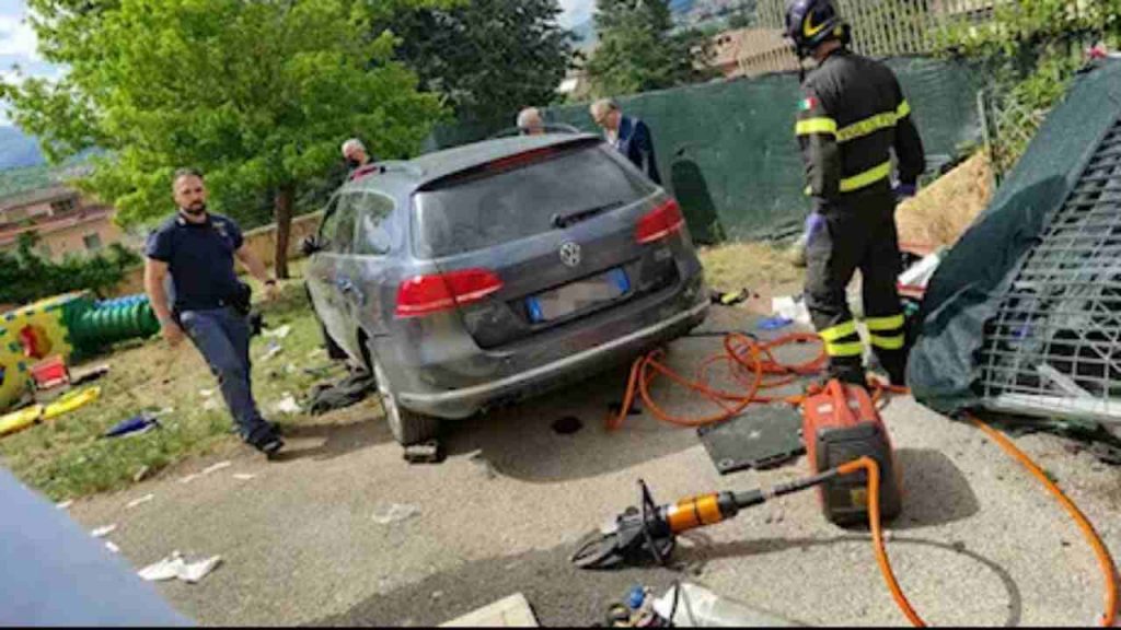 Vigili del fuoco e carabinieri che esaminano un'auto