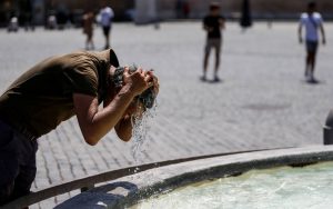 Turista trova refrigerio nella fontana di Piazza del Popolo a Roma