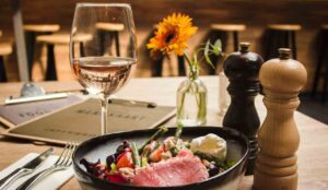 A tavola con un calice di vino e un piatto di verdure e salmone