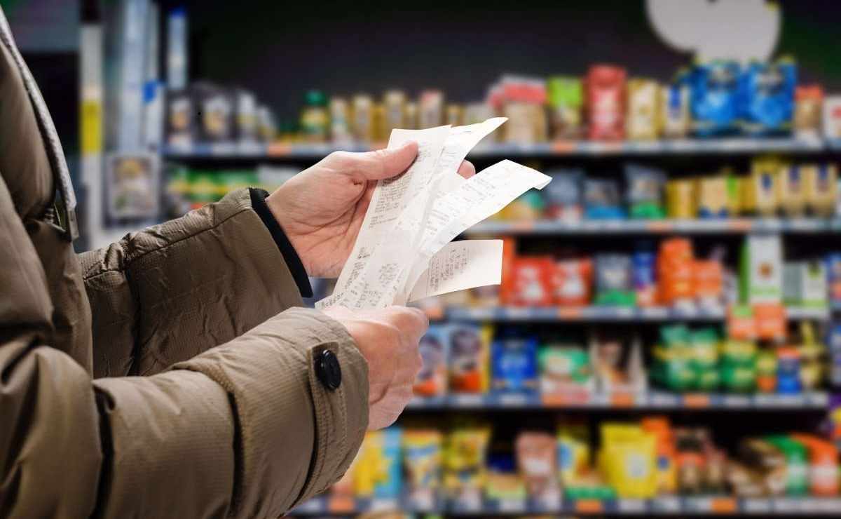 Una donna al supermercato con la lista della spesa