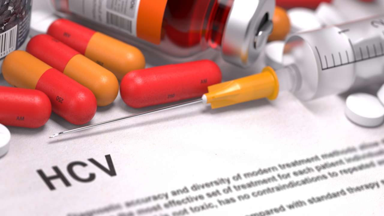 Farmaci Epatite C con pasticche colorate e siringa