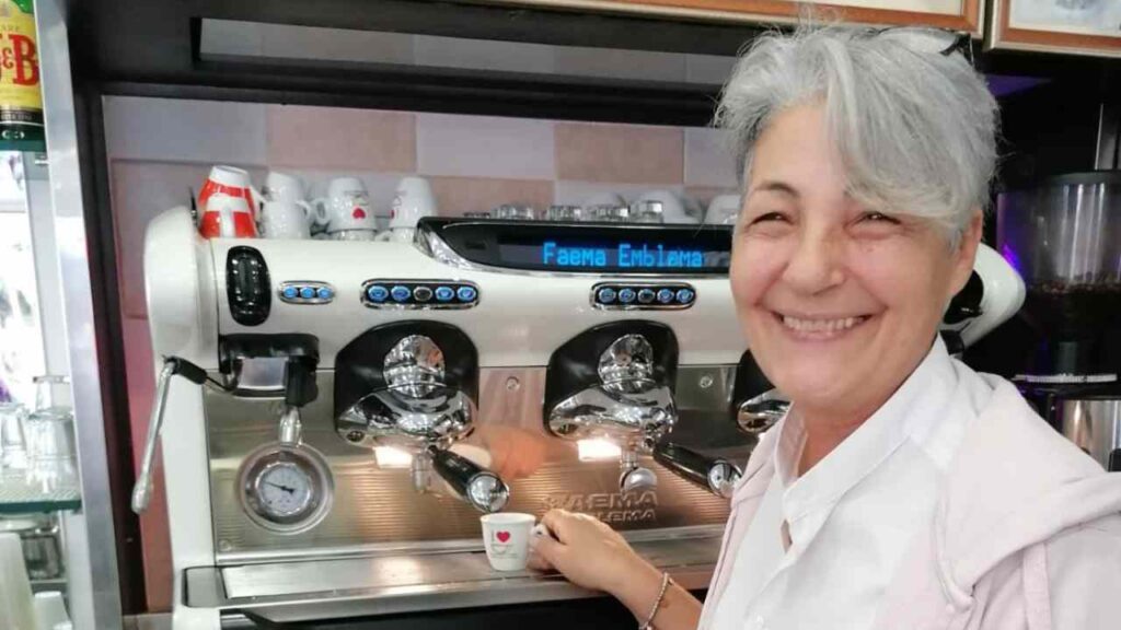 Proprietaria del Rosy bar sorridente prepara il caffè