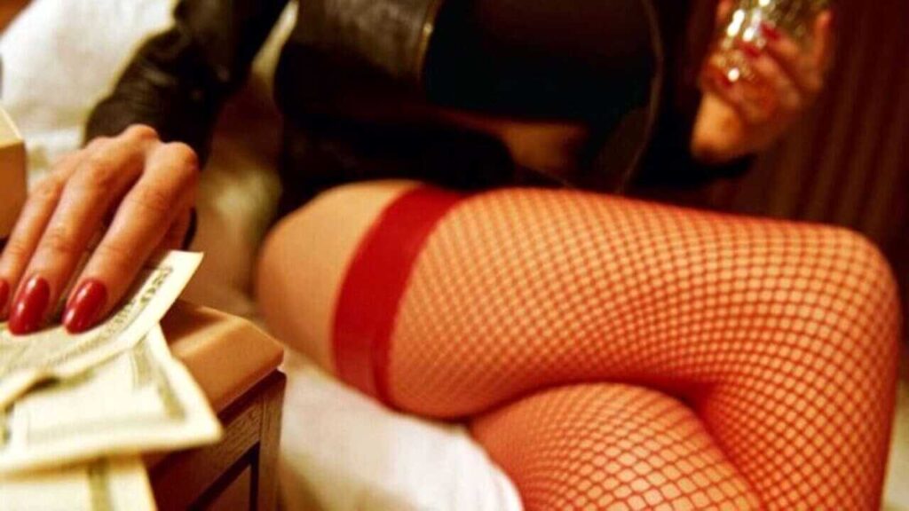 Prostituta con calze a rete e denaro in mano