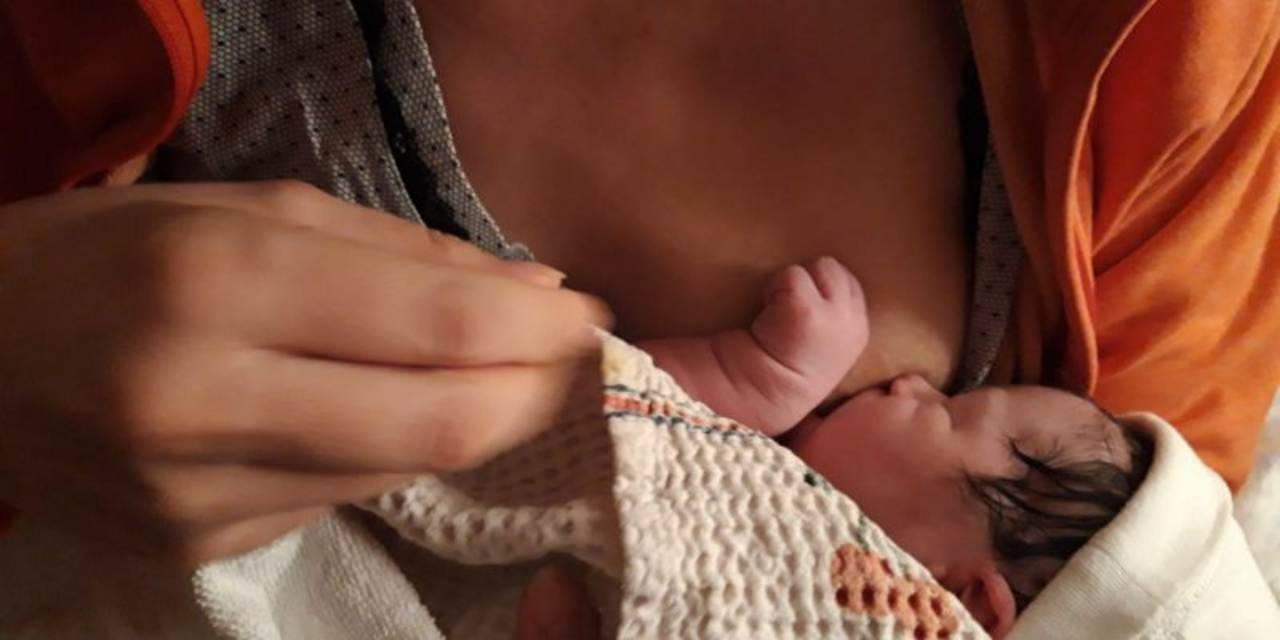 Donna con neonato al seno