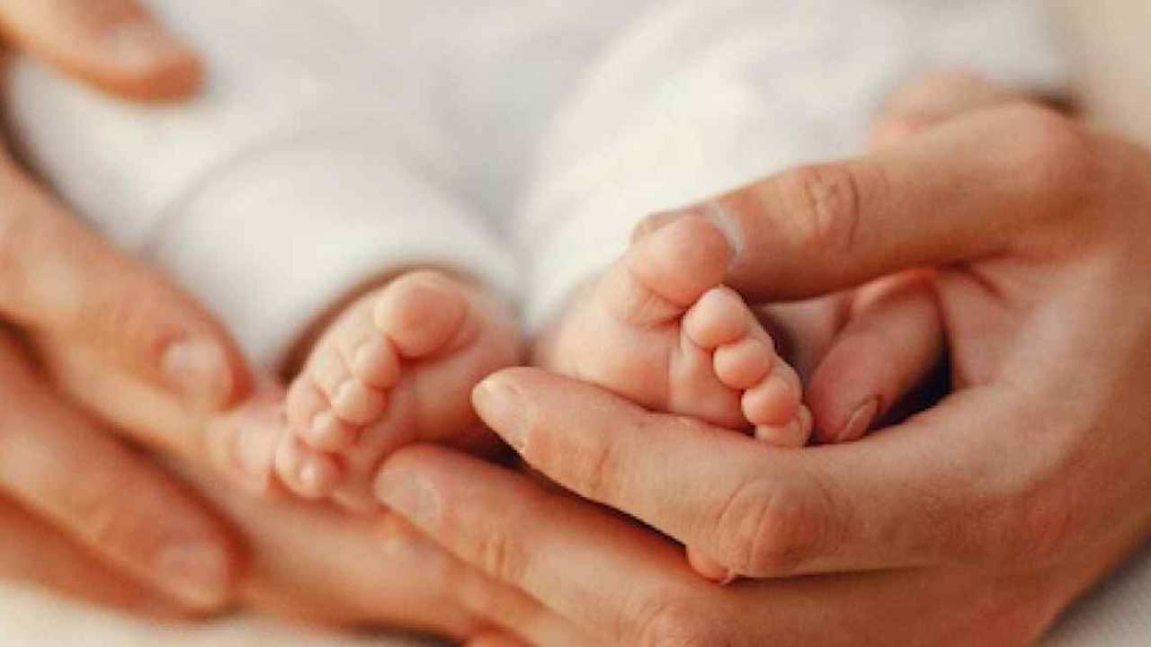Piedi di neonato con mani della mamma