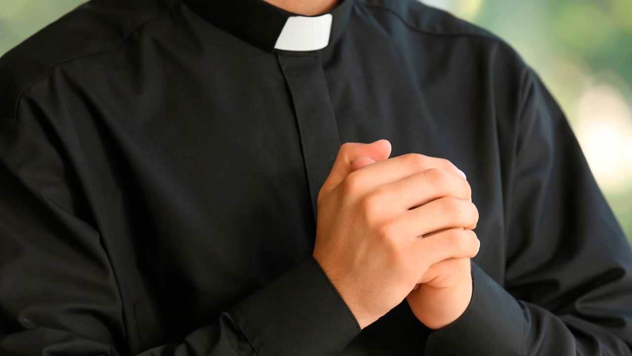 Un sacerdote con le mani giunte