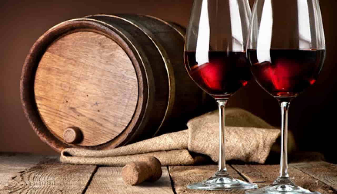Una botte e dei calici di vino rosso