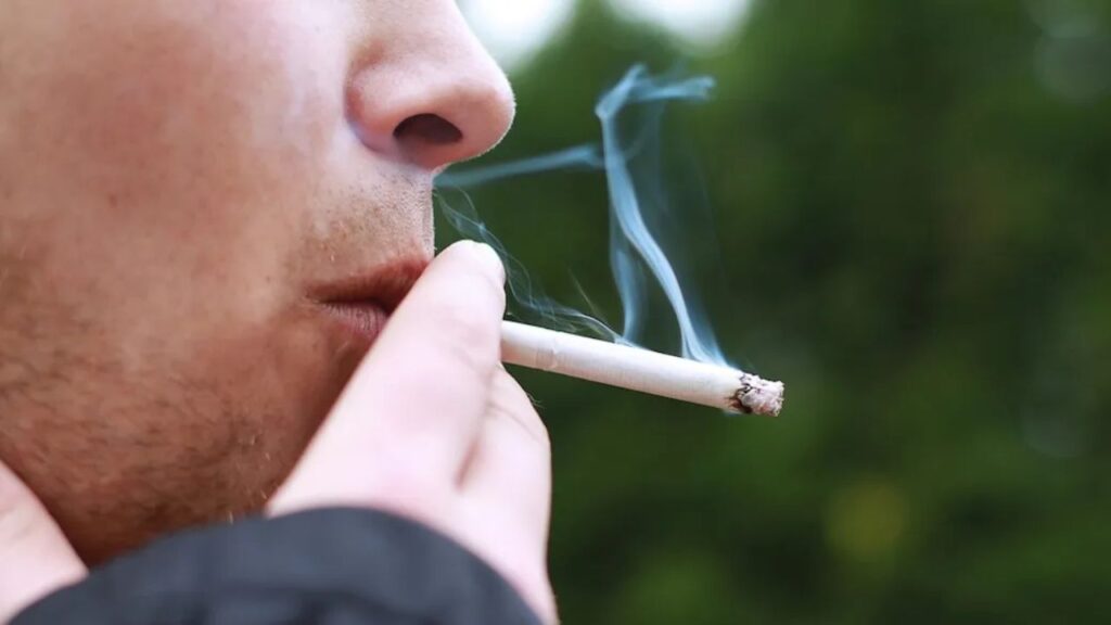 Un ragazzo che fuma una sigaretta all'aperto