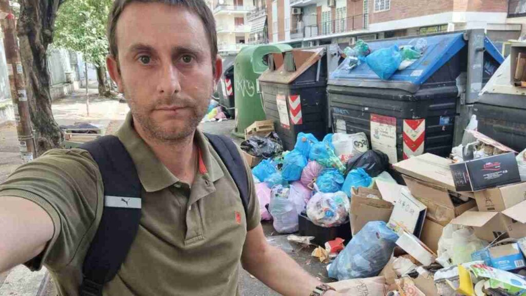 Il consigliere capitolino Daniele Diaco davanti ai cassonetti pieni e un cumulo di rifiuti lasciati a terra al Prenestino a Roma