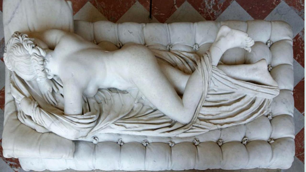 Una scultura di una donna sul letto