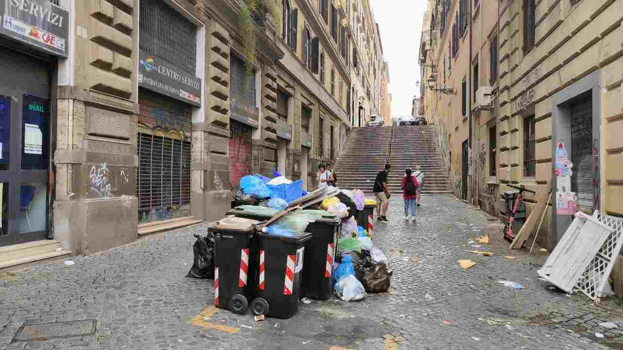 Cassonetti della spazzatura pieni, rifiuti abbandonati per terra, in una via del centro di Roma