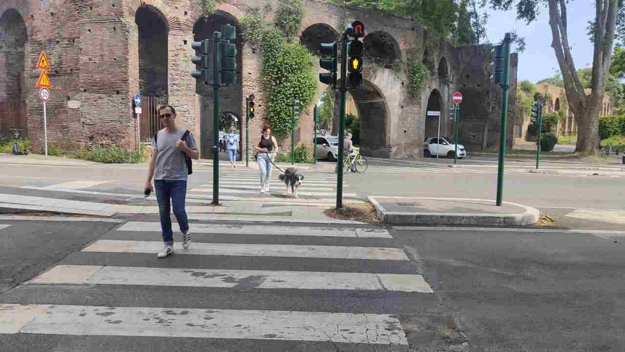 Pedone attraversa una strada di Roma sulle strisce pedonali