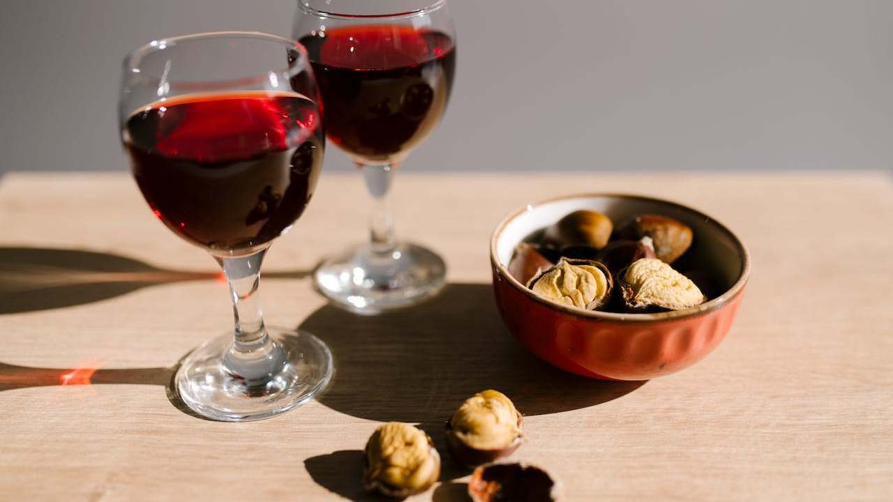 Castagne e calici di vino rosso