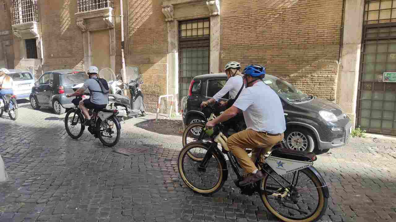 Persone per le vie della città in bici