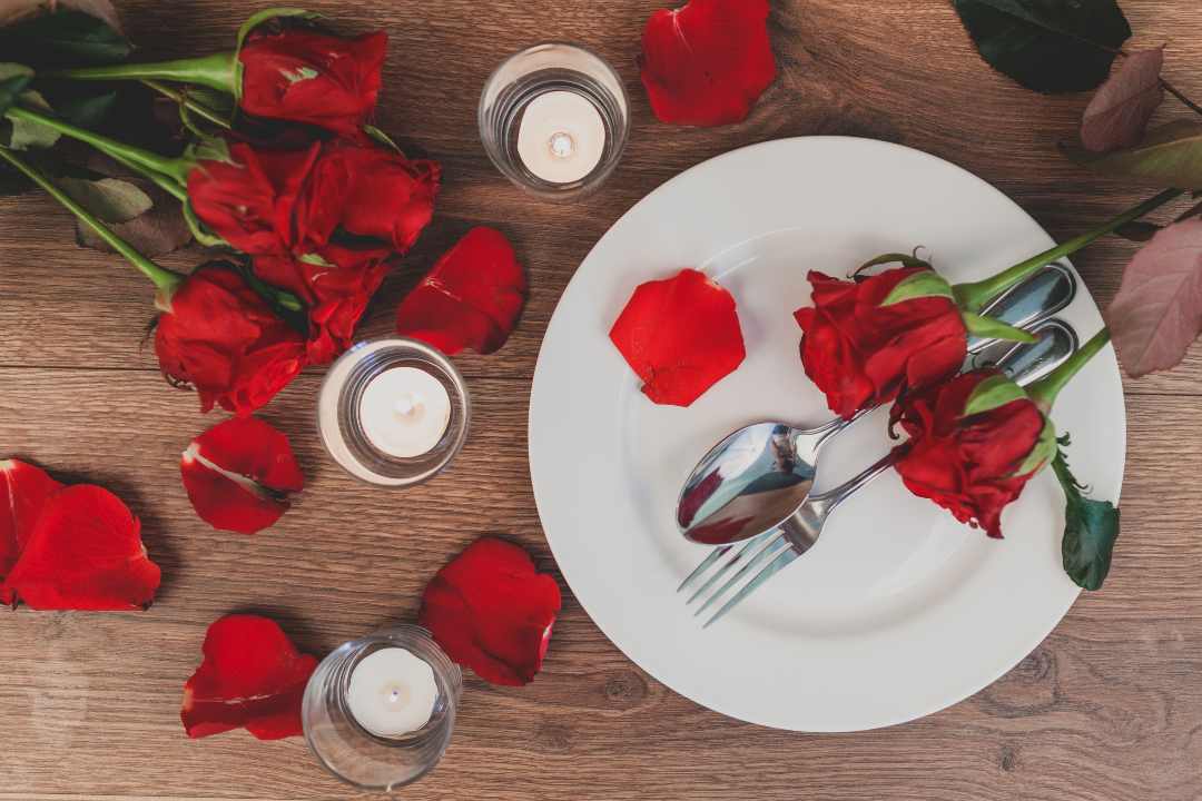 Piatto, in occasione di San Valentino, con posate e rose rosse