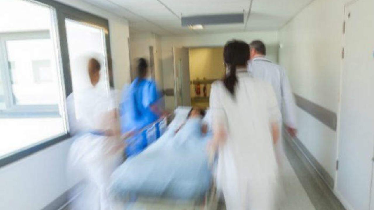 Corsia di ospedale, infermieri con paziente